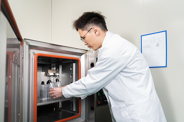 man running tests on a packaging tube using a testing machine